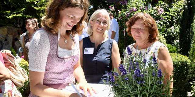 Landrätin Tanja Schweiger, Kreisverbandsvorsitzende trägt sich bei Ursula Posmik im Garten ins Gästebuch ein. (HCW)