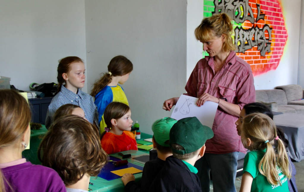 Luzie Gerb, Künstlerin zeigt den Kindern Techniken für den Druck mit Naturmaterialien.